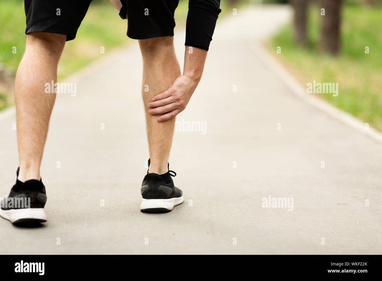 Männliche Läufer leidet an der Wade Schmerzen beim Joggen Stockfotografie -  Alamy