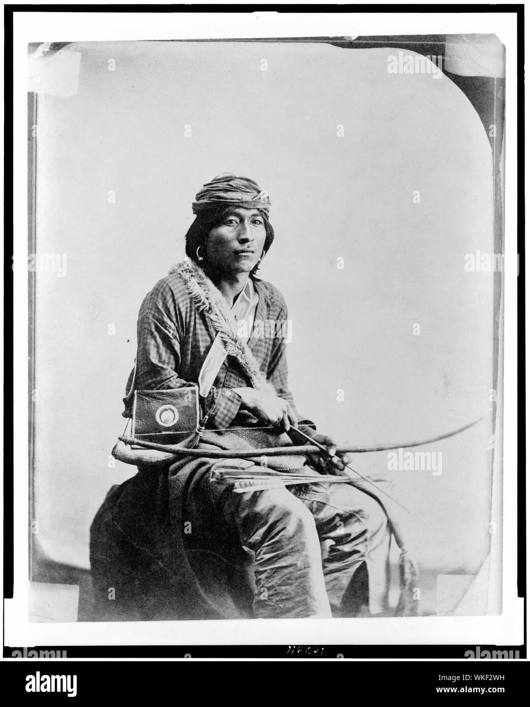 Jim, ein Navajo Indianer, drei-viertel länge Porträt, Sitzen, nach rechts gerichteter, Bogen und Pfeile Stockfoto