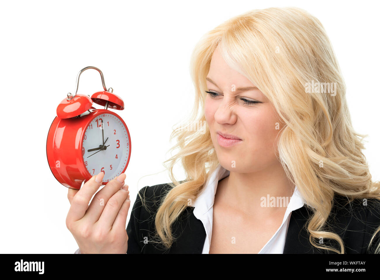 Blonde Frau Lachen unglücklich mit roten Wecker Stockfoto