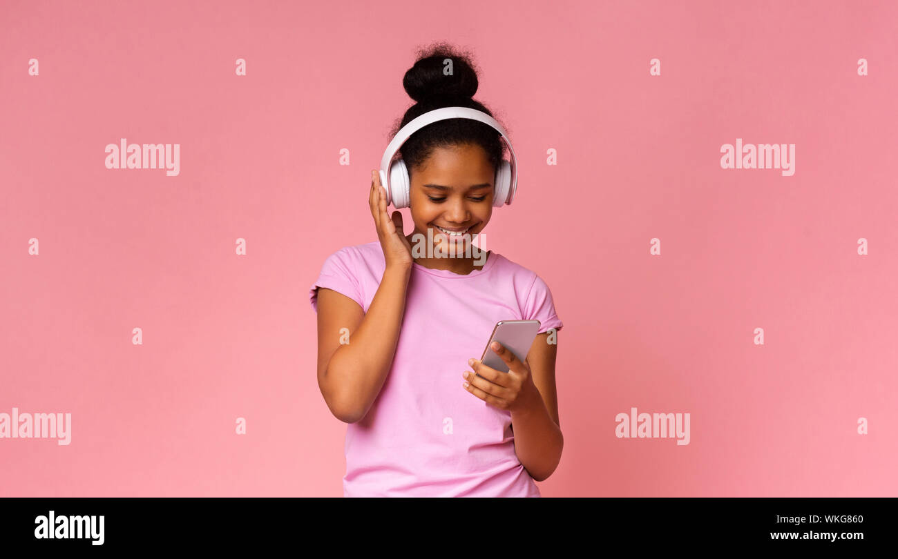 Junge schwarze Mädchen Musik auf dem Smartphone, mit der drahtlosen Kopfhörer Stockfoto