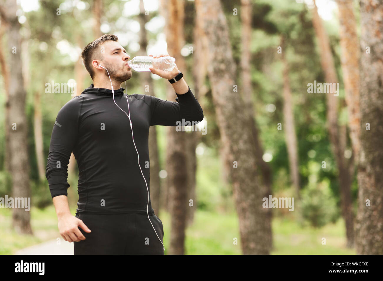 Jungen athletischen Mann Trinkwasser nach dem Training im City Park Stockfoto