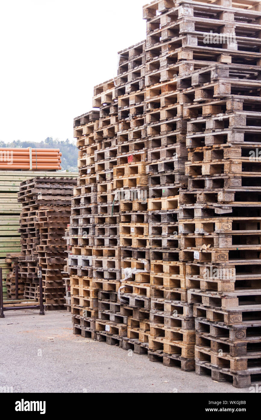 Stapel der alten Holzpaletten in einem gewerblichen oder industriellen Yard für Stacking und bewegte Ladung, Fracht und Sendungen und für Beförderung und Rohrsysteme verwendet Stockfoto