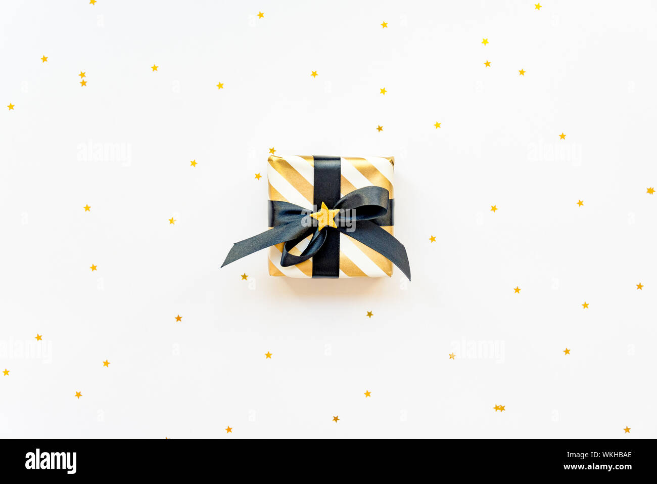 Geschenkbox über sternförmige goldenen Pailletten auf einem weißen Hintergrund. Stockfoto