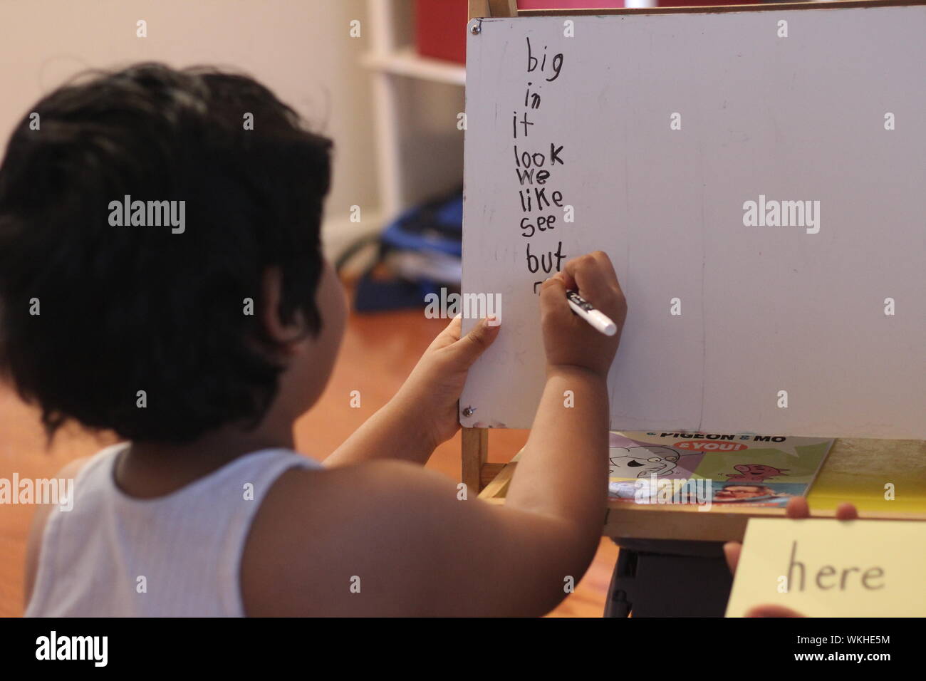 Ansicht der Rückseite des Jungen Schreiben auf dem Whiteboard zu Hause Stockfoto