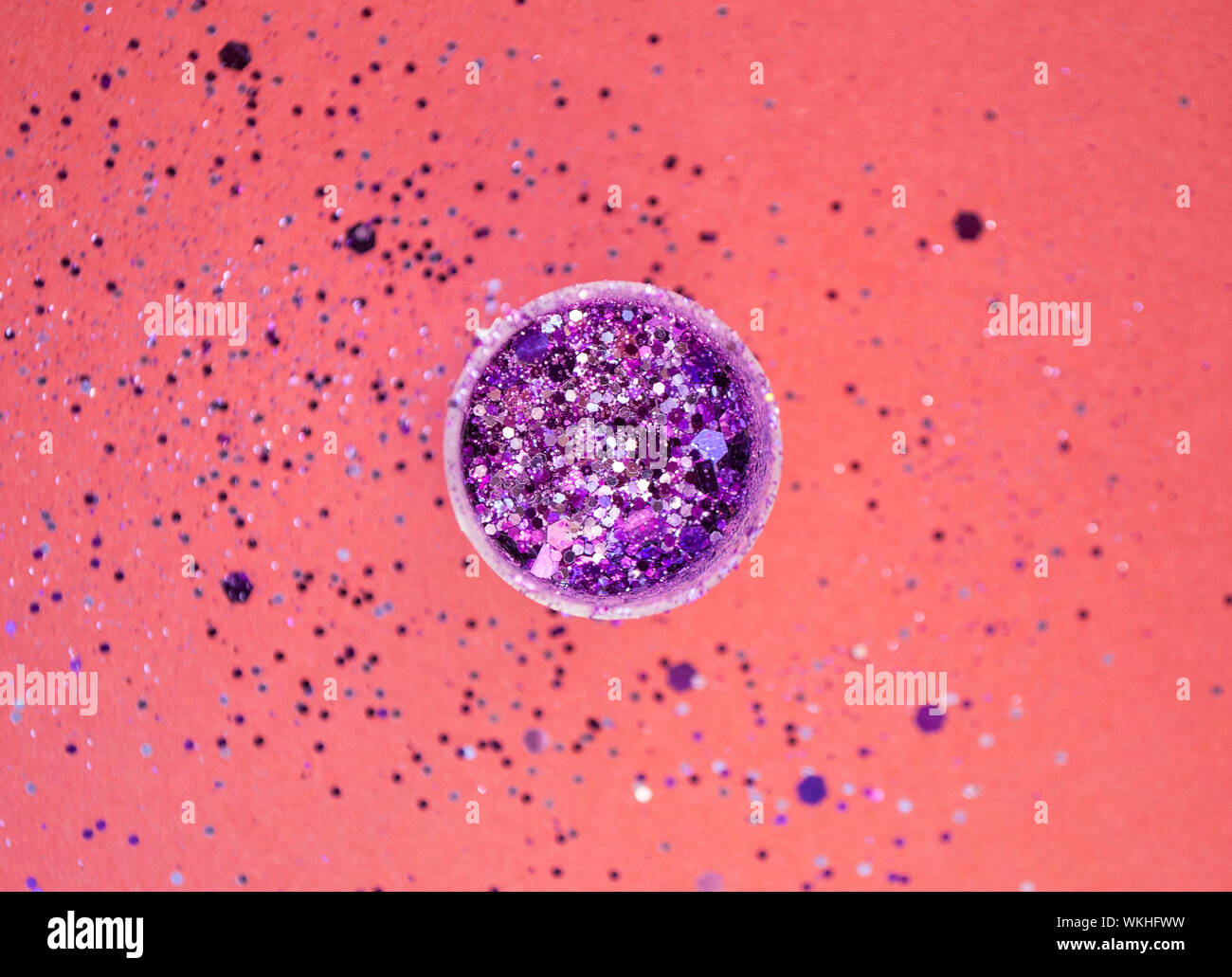 Runde Form Flasche mit lila Farbe glitter Inside auf rotem Hintergrund. Stockfoto