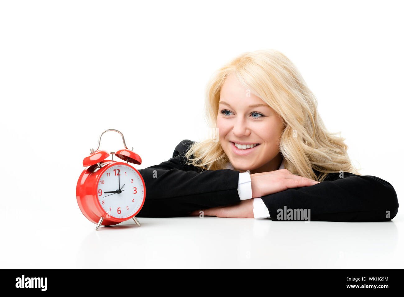 Blonde Frau mit roten Wecker lachen Stockfoto