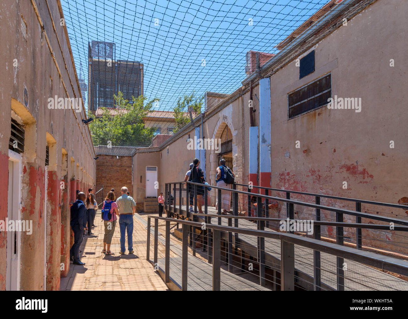 Gruppe von Besuchern auf die Isolation Zellen in Reihe vier Gefängnis, Constitution Hill, Johannesburg, Südafrika Stockfoto