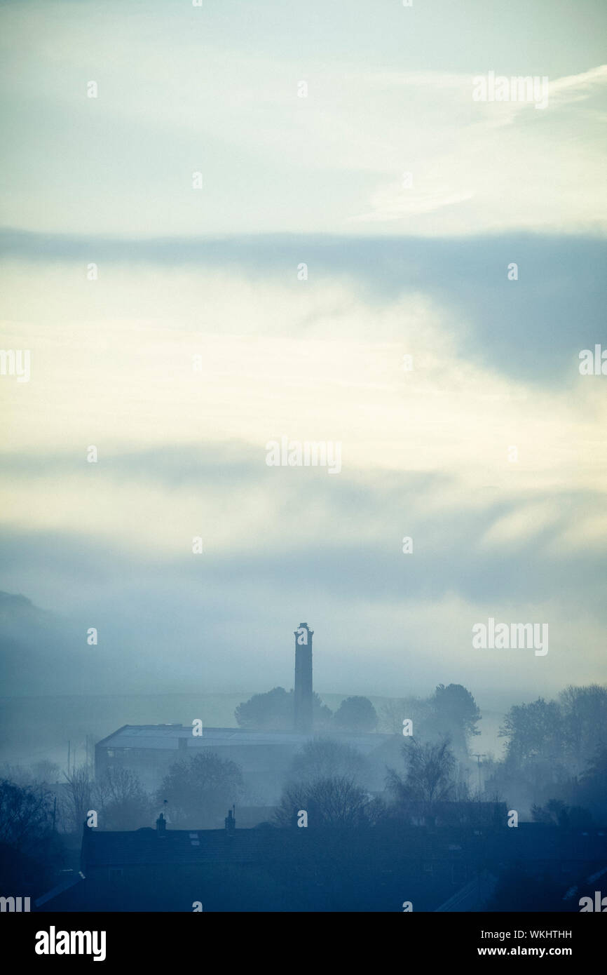 Schornstein der alten Mühle in einem nebelhaften Englisch Tal Stockfoto