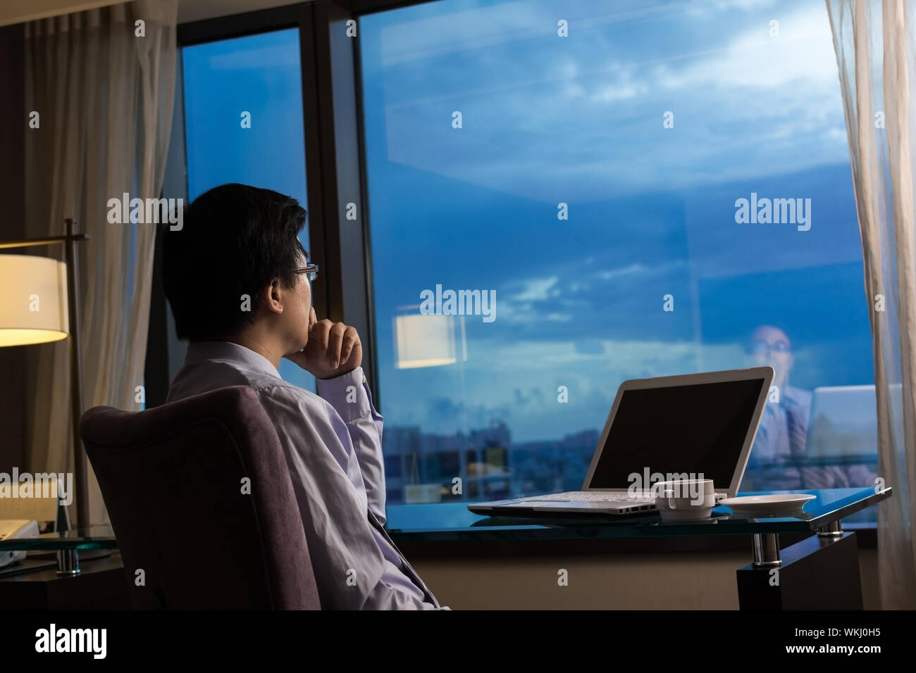 Asiatische Geschäftsmann in einem Raum sitzen und Blick in die Ferne, Konzept des Reisens Geschäft, träumen, arbeiten in der Nacht etc.. Stockfoto