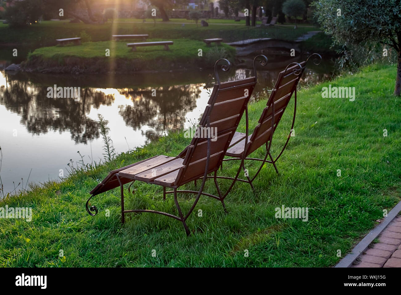 Zone Rest. Hölzerne Stühle stehen auf der Wiese am See, mit Blick auf den See. Weißrussland Stockfoto