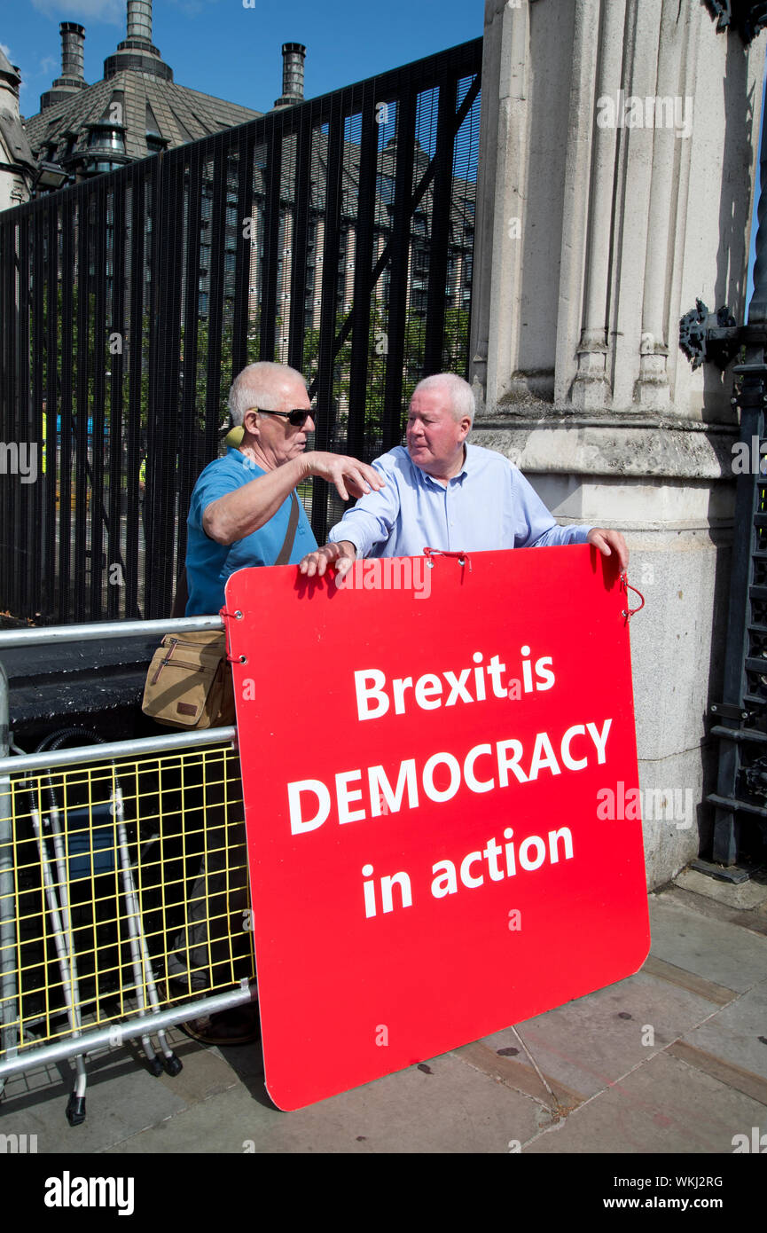 4. September 2019 das Parlament. Zwei Schulabgänger mit einem großen Plakat sagt 'Brexit Demokratie in Aktion" ist. Stockfoto