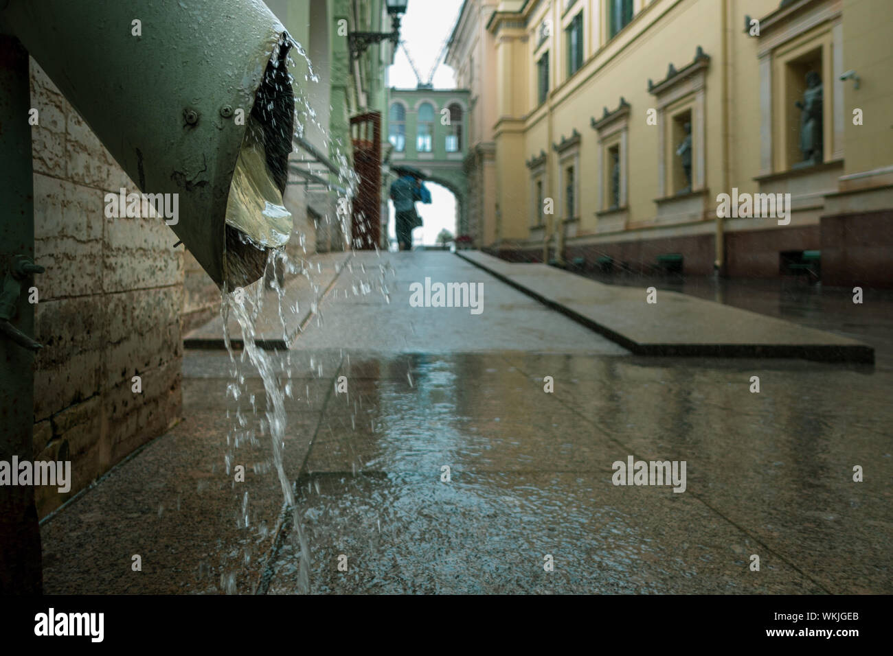 Kreative Schuß Wasser gießt aus einem riesigen auspuffrohrs am Hermitage an einem regnerischen Tag Wolkenbruch, in St. Petersburg, Russland Stockfoto