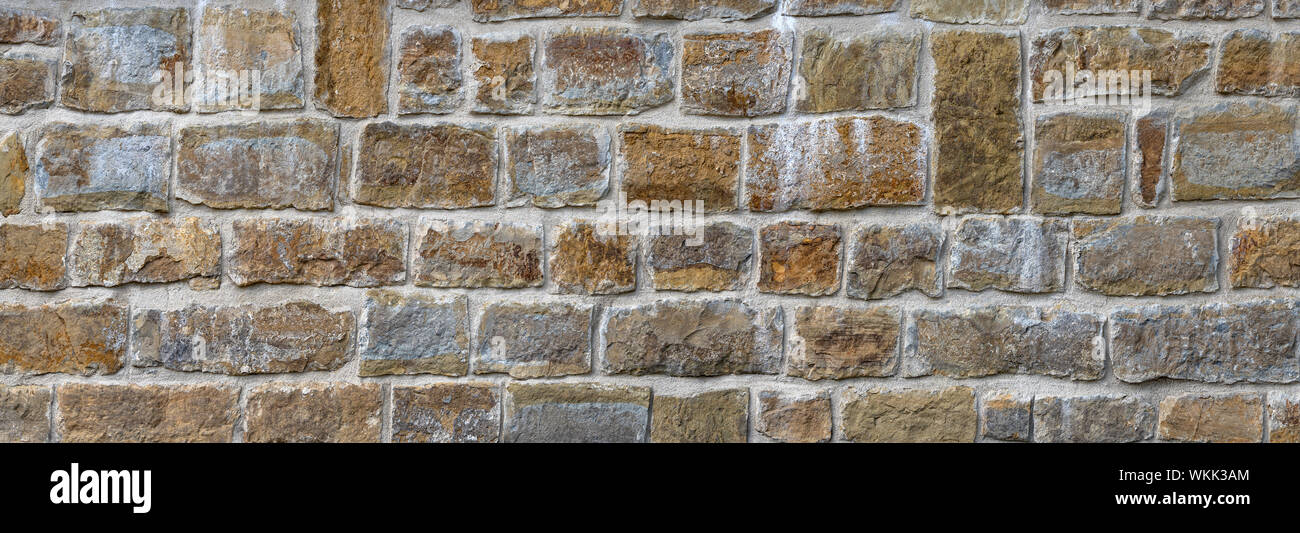 Alte Mauer aus Natursteinen in Zeilen Stockfoto