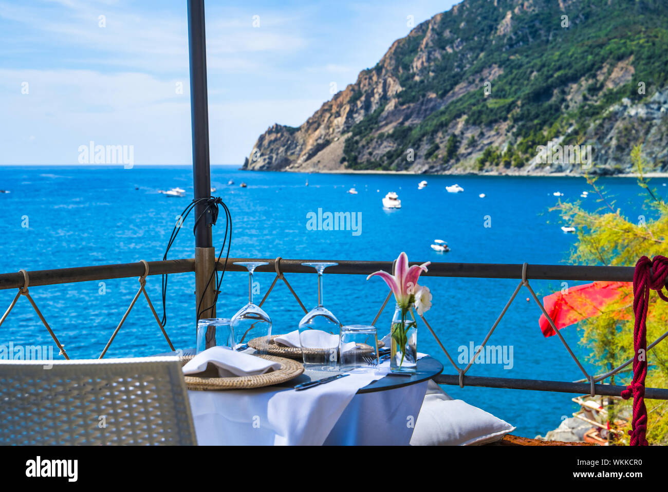 Elegant serviert Tabelle mit Meer-/Bergblick auf das Meer/Weingläser und eine Blume in einer Vase/Restaurant in Monterosso Stockfoto