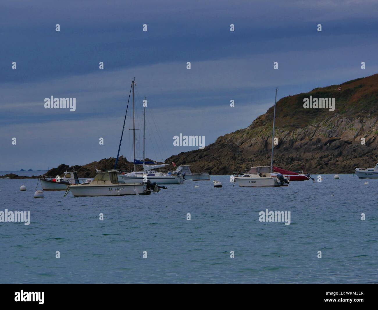 Bateaux de Plaisance ancrés devant La plage de Brest derrière les rochers et des îlots de Rochers Stockfoto