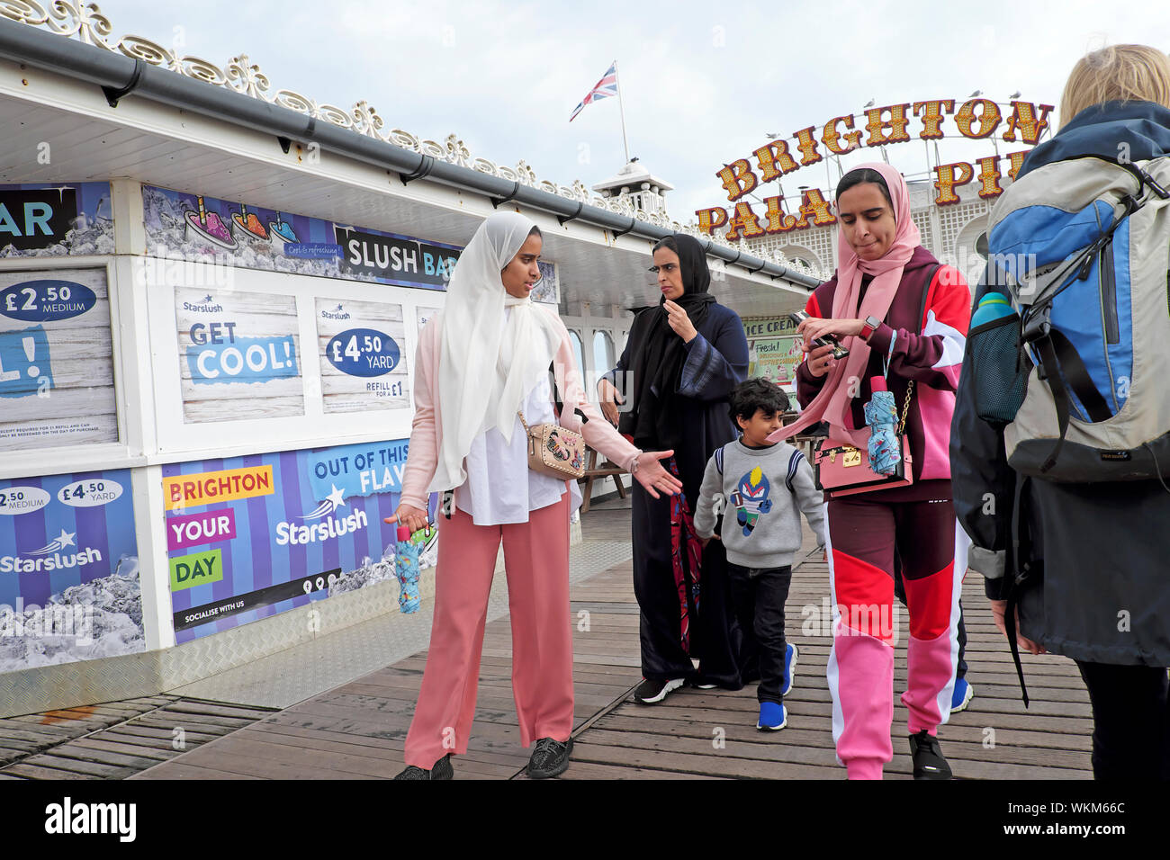 Asiatische Frauen mit Kopftüchern und Kind entlang Brighton Pier im Sommer an der Brighton East Sussex England UK KATHY DEWITT Stockfoto