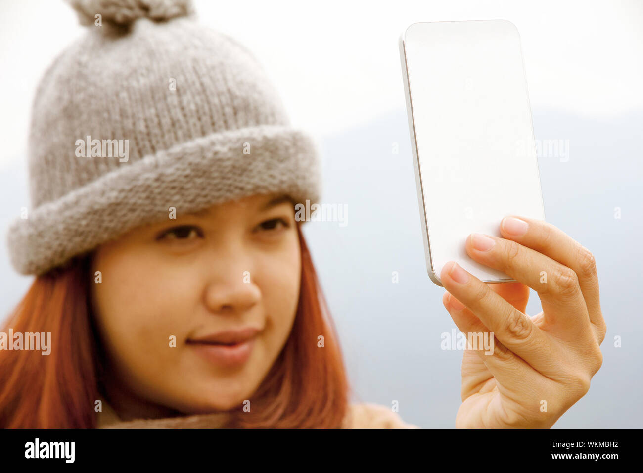 Gerne asiatische Frauen an ihrem Handy suchen Stockfoto