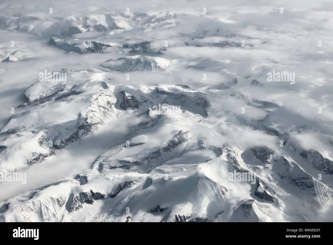 Blick aus dem Flugzeug auf verschneite Berglandschaft, eye Bird's View, Grönland Stockfoto