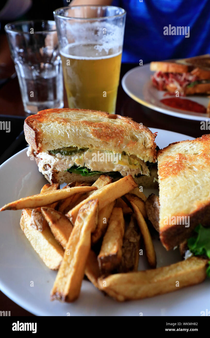 Ein Teller mit Hühnerhuck-Sandwiches mit französischem und einem Pint Bier auf dem Tisch im Restaurant.Kennebunkport.Maine.USA Stockfoto