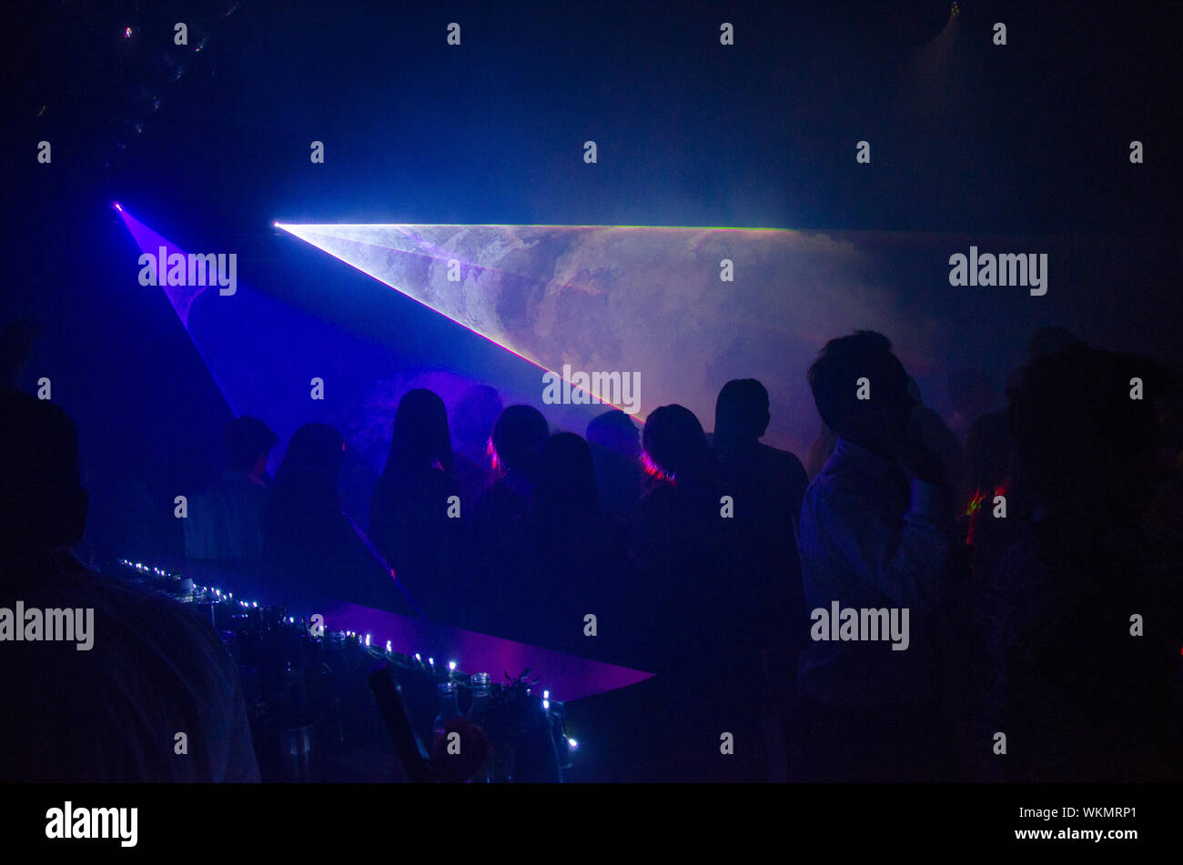 Lichtstrahlen, die auf Menschen in Nachtclub Stockfoto