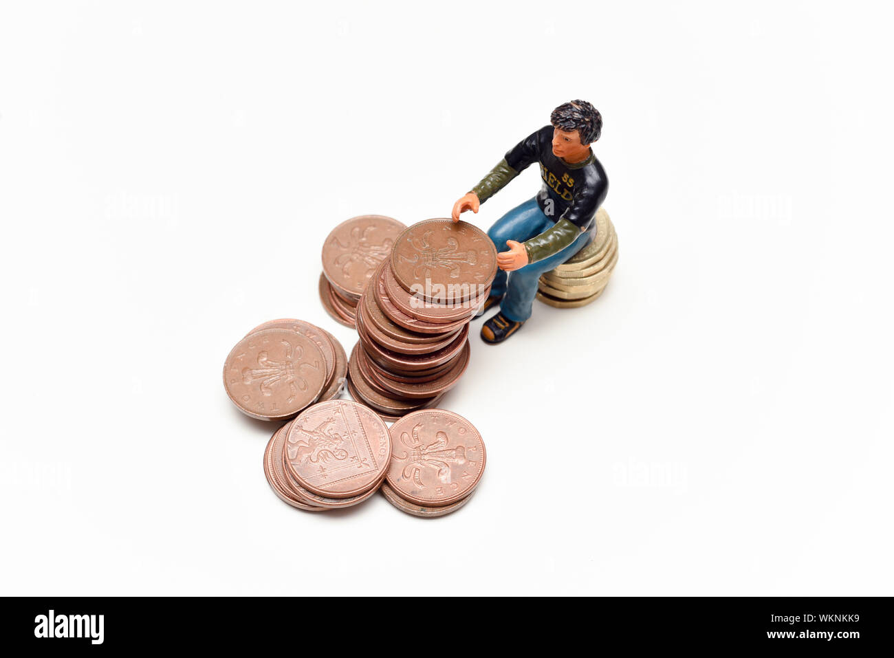 Geld sparen und Geld verdienen. Der Mann sitzt auf einem Stapel auf Münzen Stockfoto