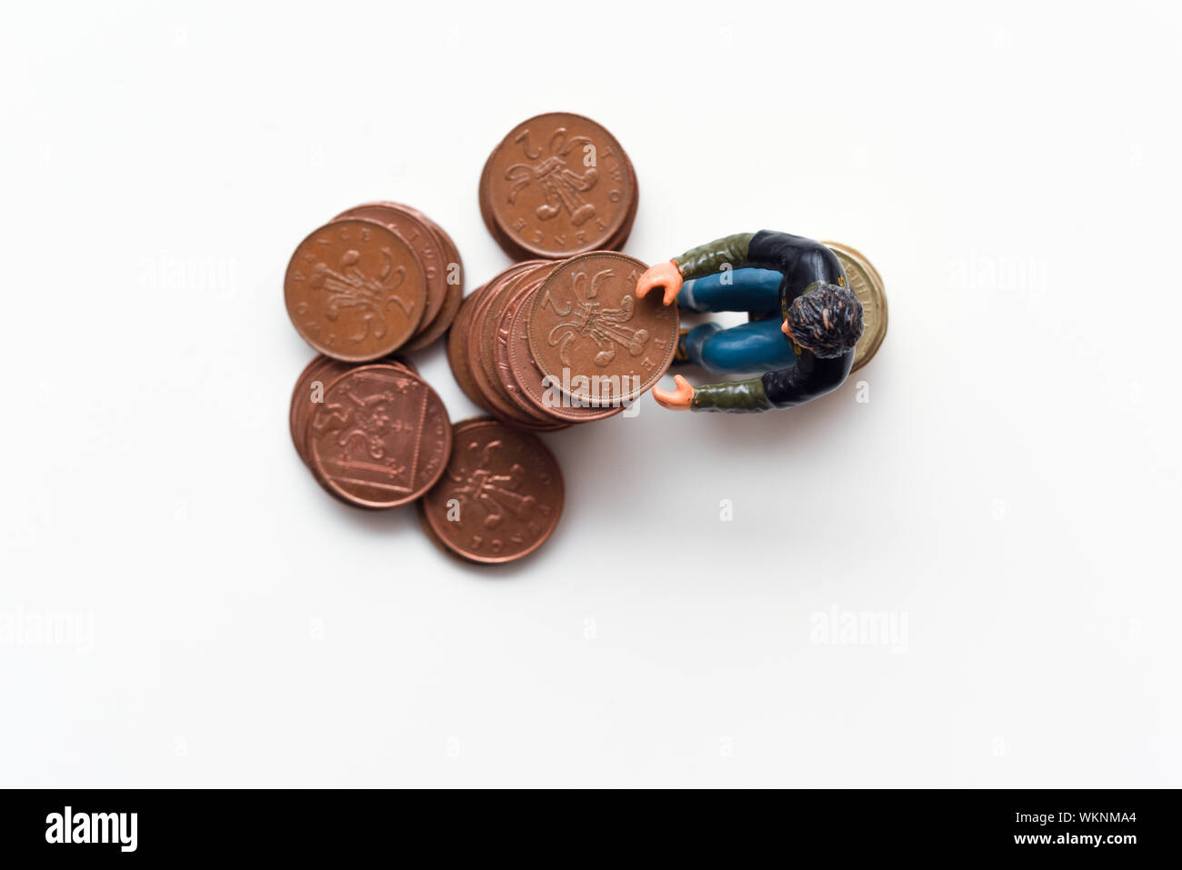 Geld sparen und Geld verdienen. Der Mann sitzt auf einem Stapel auf Münzen Stockfoto