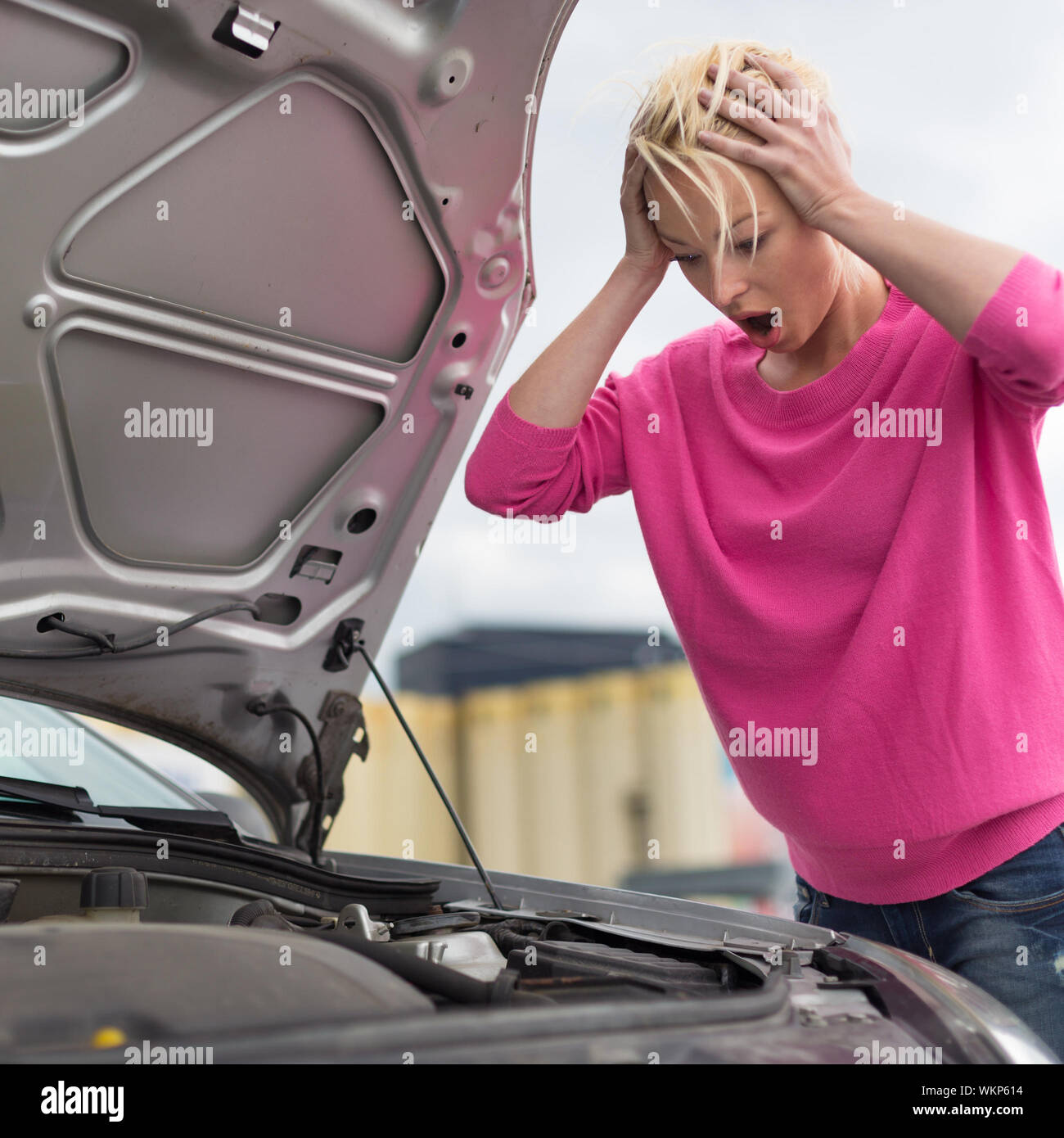 Junge Frau mit Auto defekt, betonte. Stockfoto