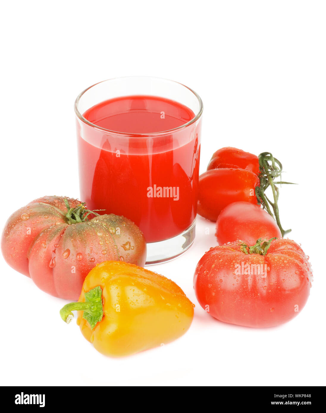 Anordnung Frisch gepresster Tomatensaft im Glas und verschiedene Tomaten und Orangen Paprika isoliert auf weißem Hintergrund Stockfoto