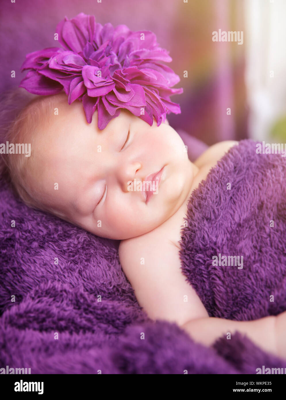Porträt von niedlichen kleinen neugeborenen Mädchen zu Hause schlafen, tragen stilvolle Blume Zubehör, Zärtlichkeit und Baby-Mode-Konzept Stockfoto