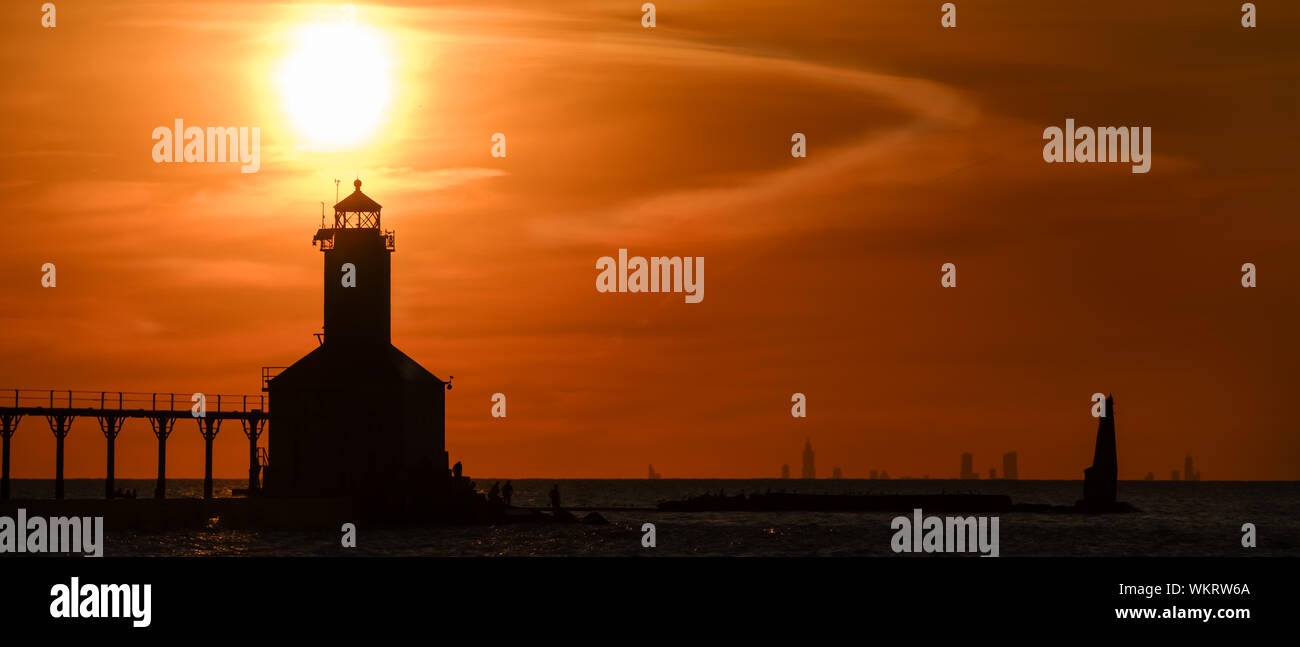 Michigan City, Indiana USA/08-25-2019: Washington Park ikonischen Leuchtturm Silhouette in einer dramatischen Goldenen Stunde Sonnenuntergang mit Chicago in der Rückseite Stockfoto