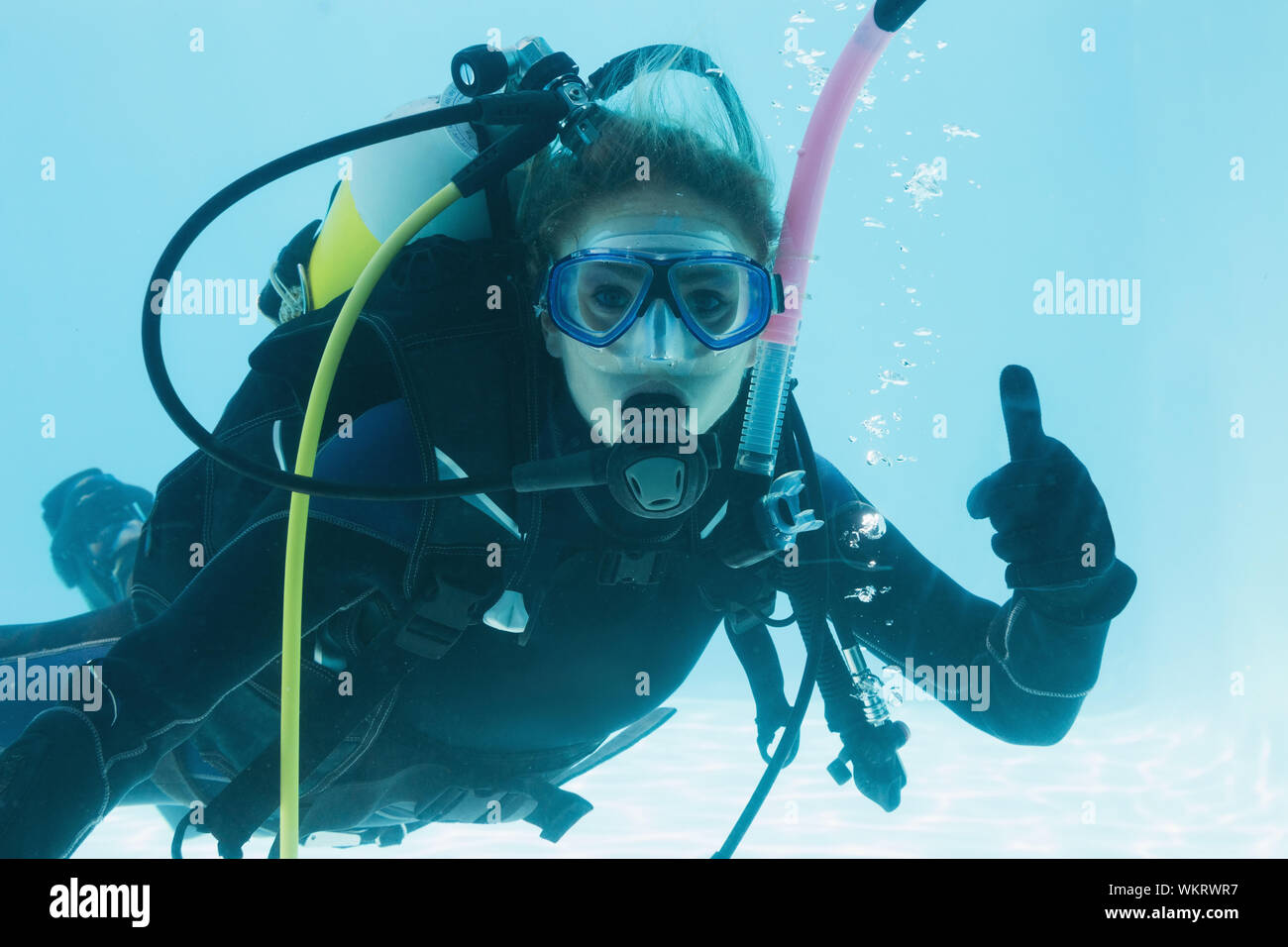 Frau auf scuba Training im Schwimmbad Daumen oben auf ihr Urlaub unter Wasser Stockfoto