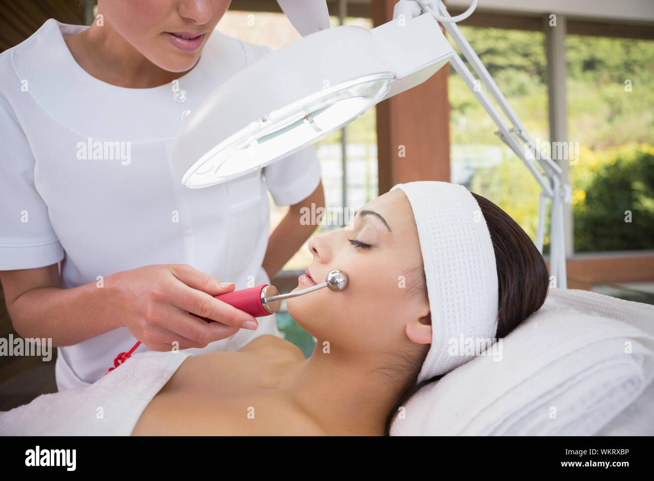 Friedliche brunette getting Micro Dermabrasion von kosmetikerin im Health Spa Stockfoto