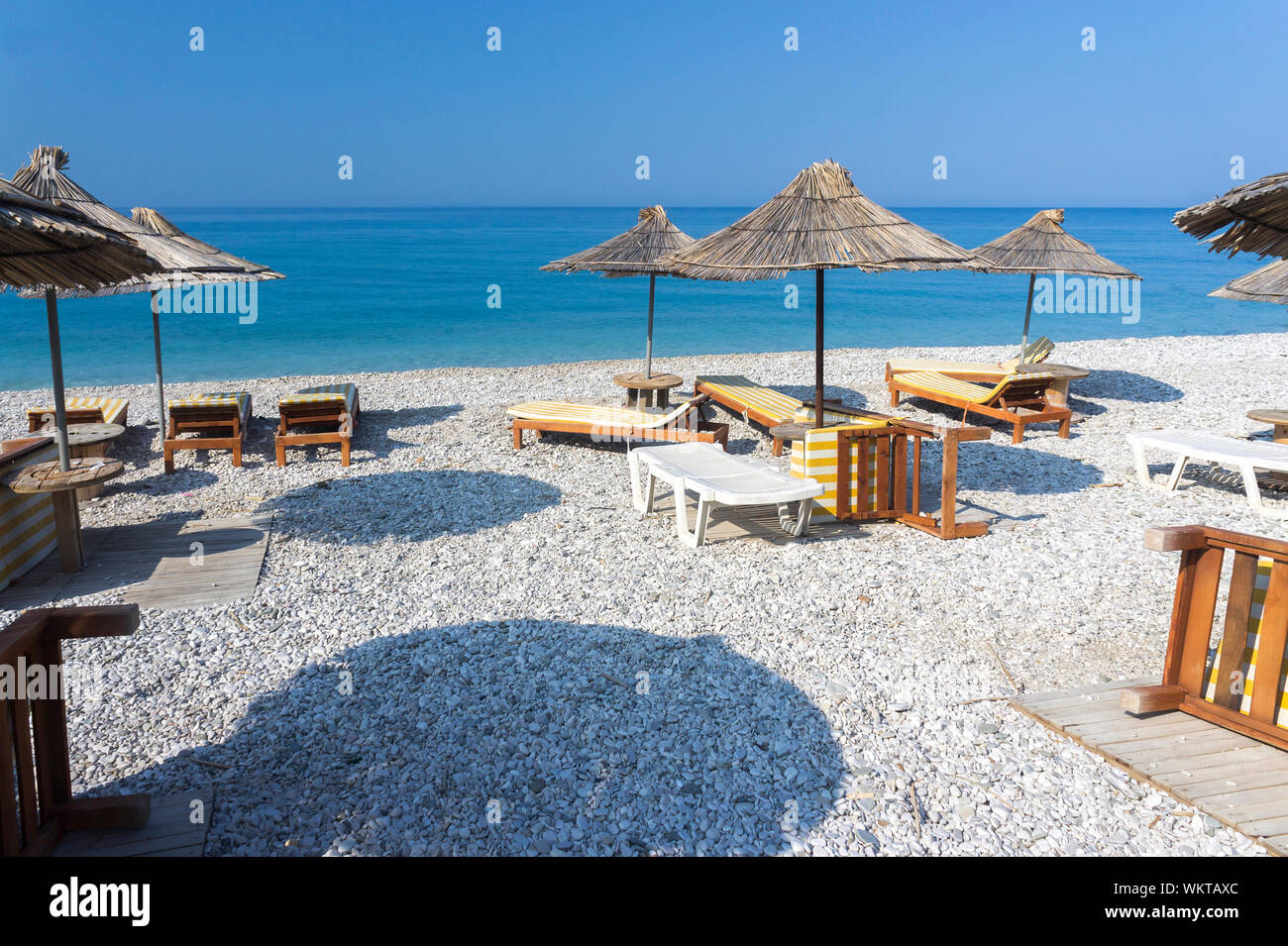 Leere Liegestühle an der See. Unter einem Vordach. Borsh Albanien Stockfoto