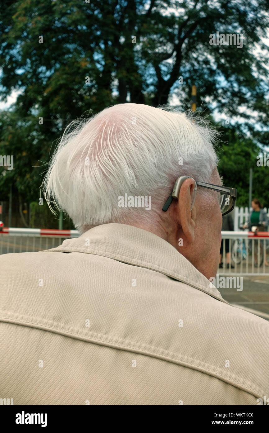 Nahaufnahme Rückansicht ein grauhaariger alter Mann 2 Hörgeräte tragen Stockfoto