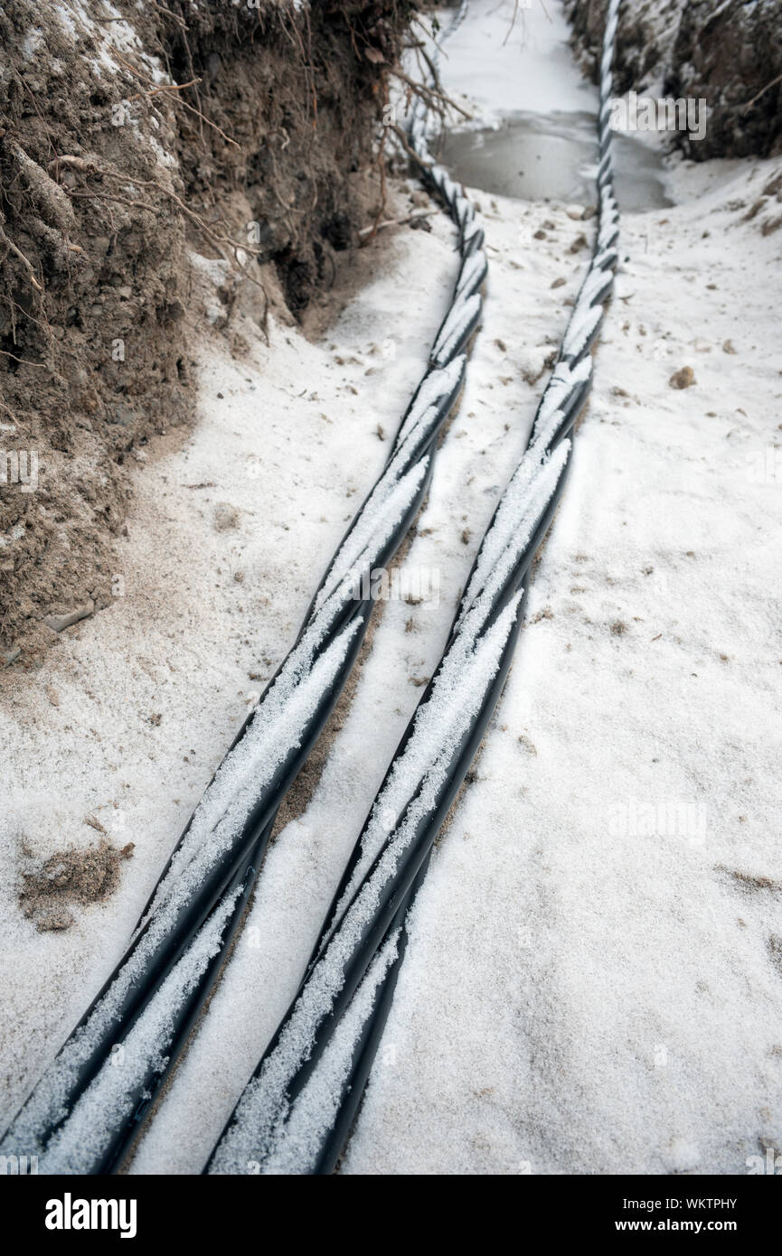 Verlegung der Glasfaser- und Stromleitungen in den gefrorenen Boden, Erdkabel für schnelles Internet im ländlichen Raum - unterirdische Verkabelung in Finnland Stockfoto