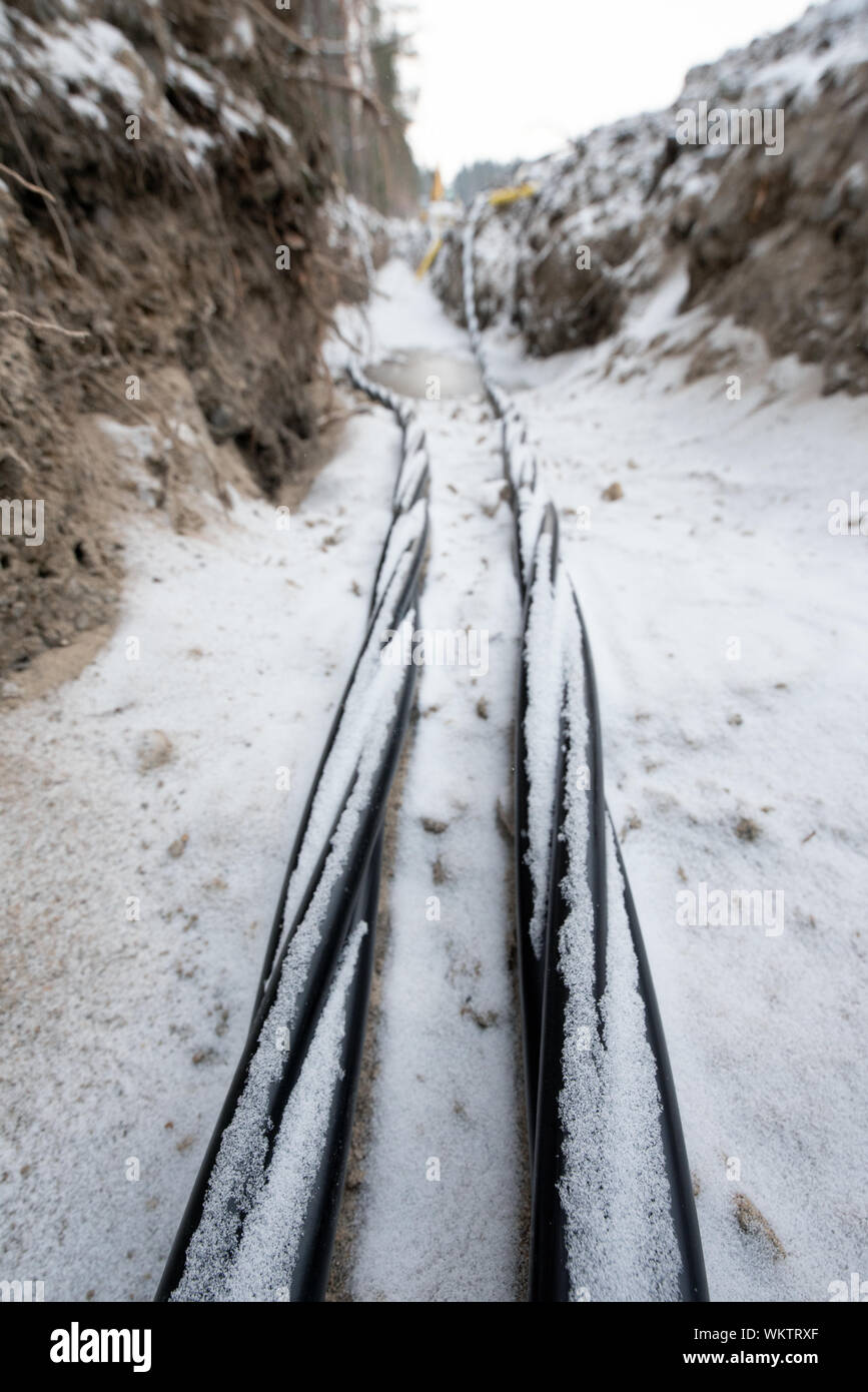 Verlegung der Glasfaser- und Stromleitungen in den gefrorenen Boden, Erdkabel für schnelles Internet im ländlichen Raum - unterirdische Verkabelung in Finnland Stockfoto