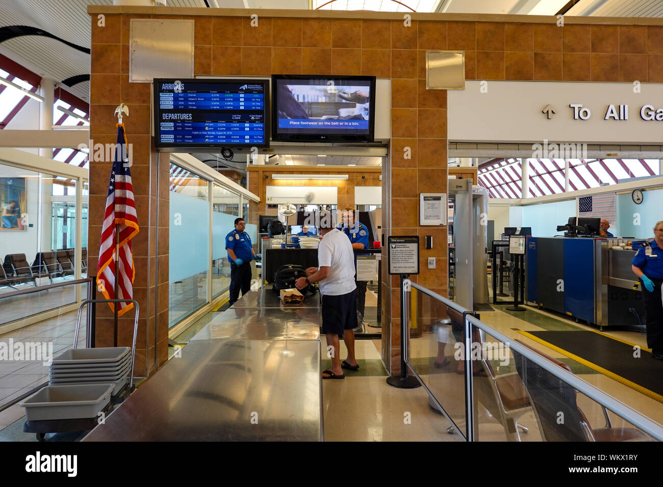 Bloomington, IL/USA -8/25/19: Ein Mann, sein Gepäck auf den Riemen zu haben Sie für Waffen und Bomben auf der TSA-Check Point xrayed auf regionaler Stockfoto