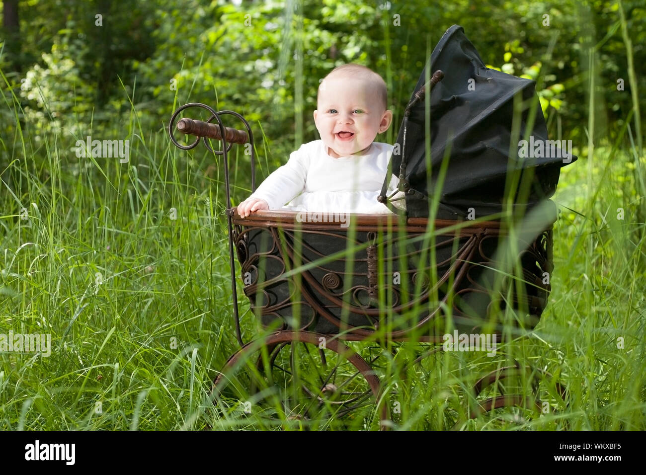 Baby in Vintage Kinderwagen Stockfoto