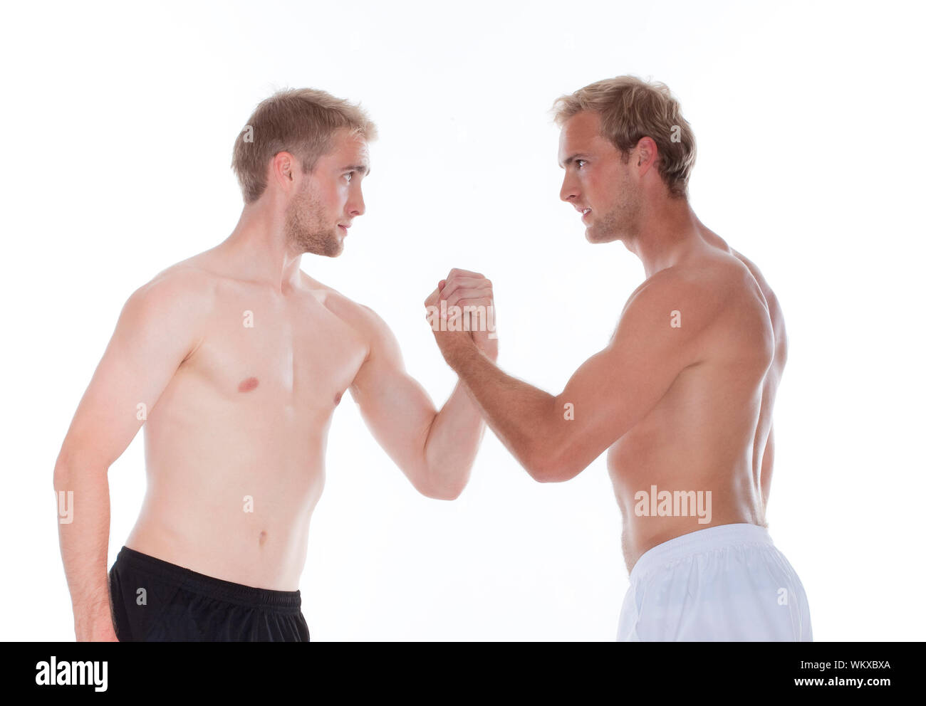 Zwei junge Männer in Shorts ringen - isoliert auf weißem Stockfoto