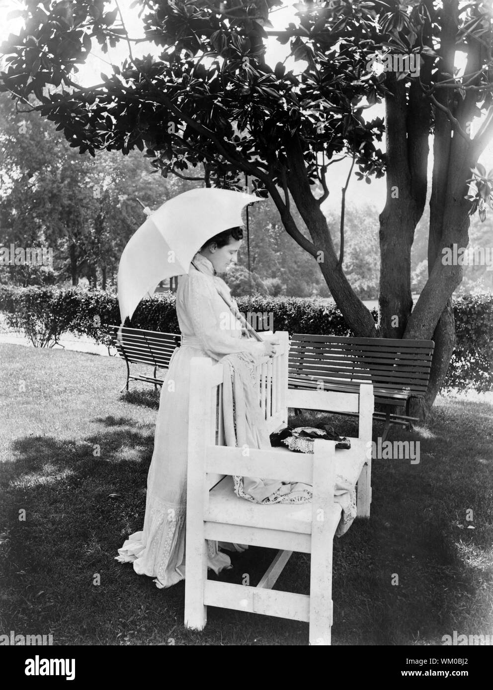 Frau Edith Roosevelt, in voller Länge Porträt, hinter Sitzbank, nach rechts gerichteter, Regenschirm, Foto von Charles Milton Bell, August 1904 Stockfoto