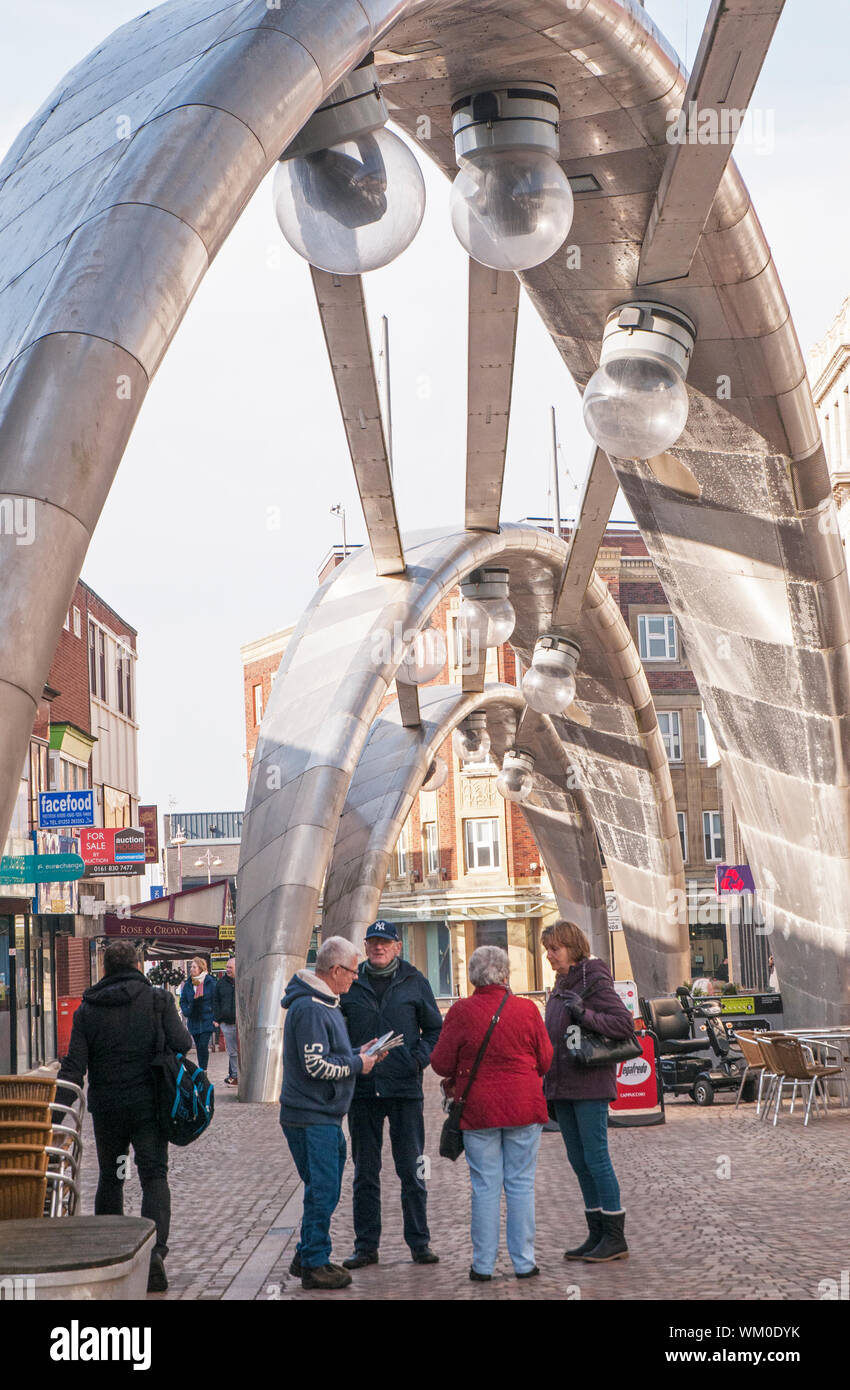 Gruppe von Menschen, die im Gespräch unter modernen futuristische Edelstahl Projektion Beleuchtung in Blackpool, Lancashire, England UK Bögen Stockfoto