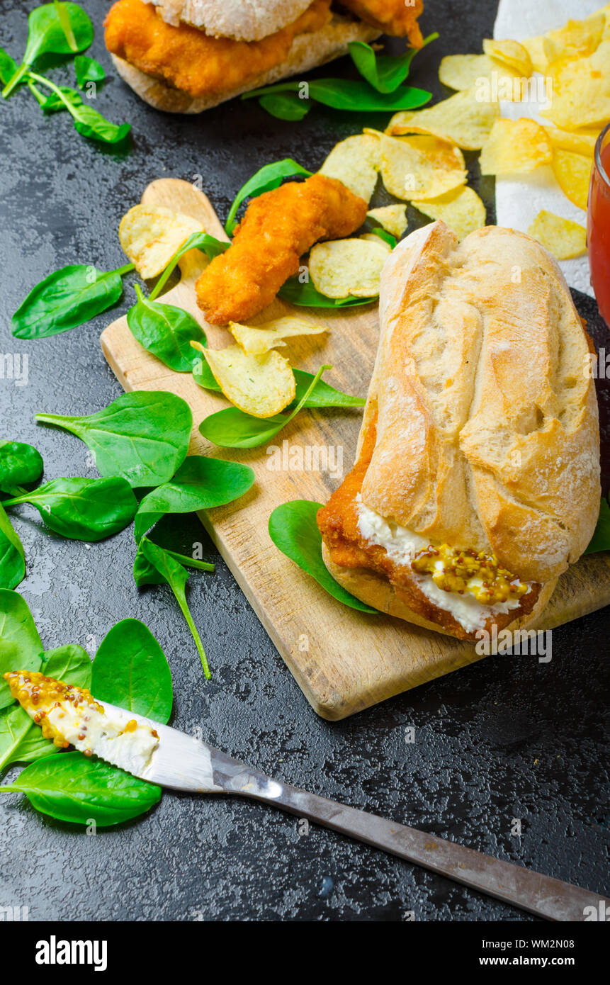 Schnitzel mit pikanter Dip und Spinat in ein rustikales Baguette und hausgemachte Pommes frites Stockfoto