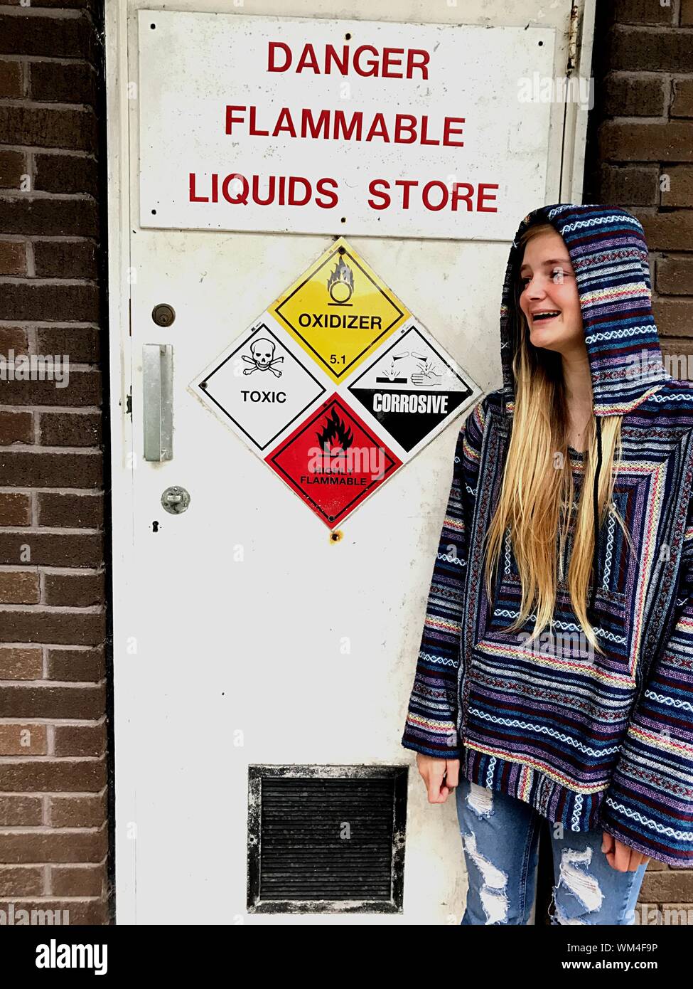 Lächelnden jungen Frau, die auf der Suche nach Warnschild an Tür Stockfoto