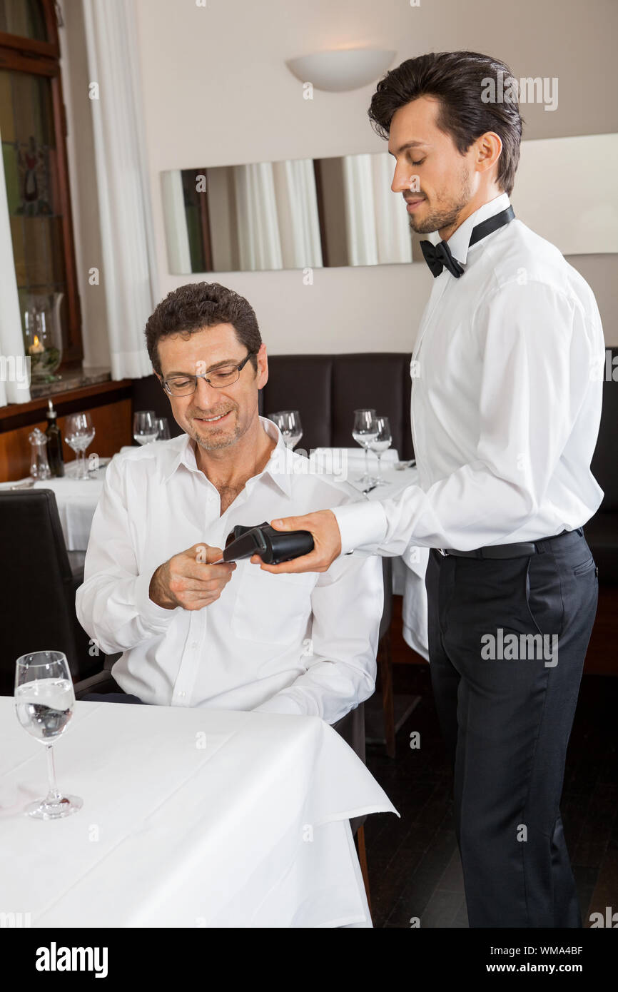 Abendessen im Restaurant Mann und Frau bezahlen per Kreditkarte Stockfoto