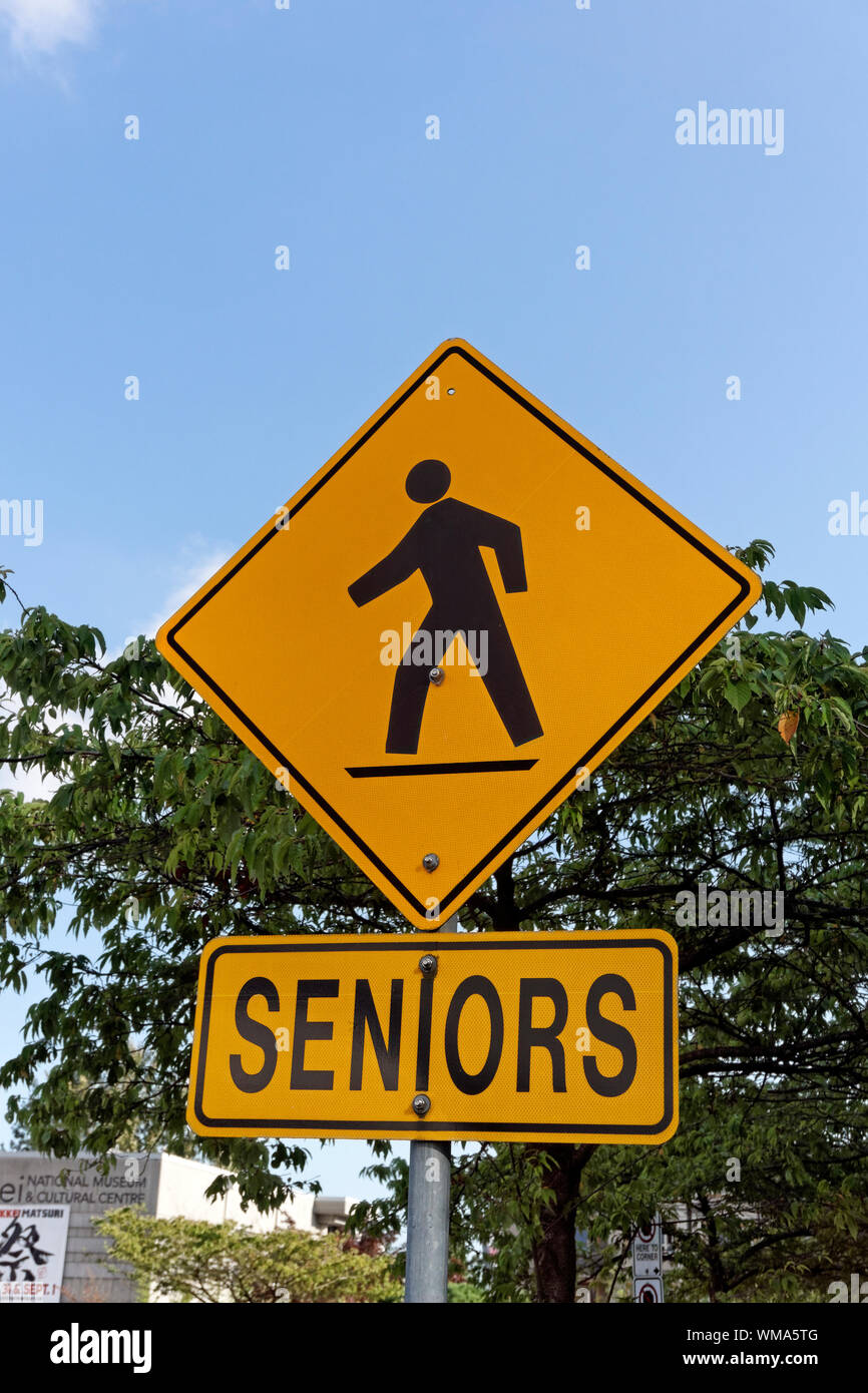 Nahaufnahme von Gelb und Schwarz Senioren Fußgänger überqueren Zebrastreifen Zeichen, Vancouver, BC, Kanada Stockfoto