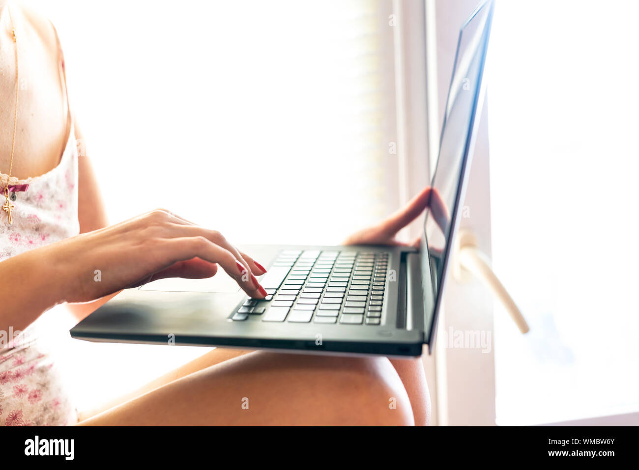 Der Prozess der Texteingabe auf einem Laptop Tastatur auf einem Hintergrund von hellem Sonnenlicht Stockfoto