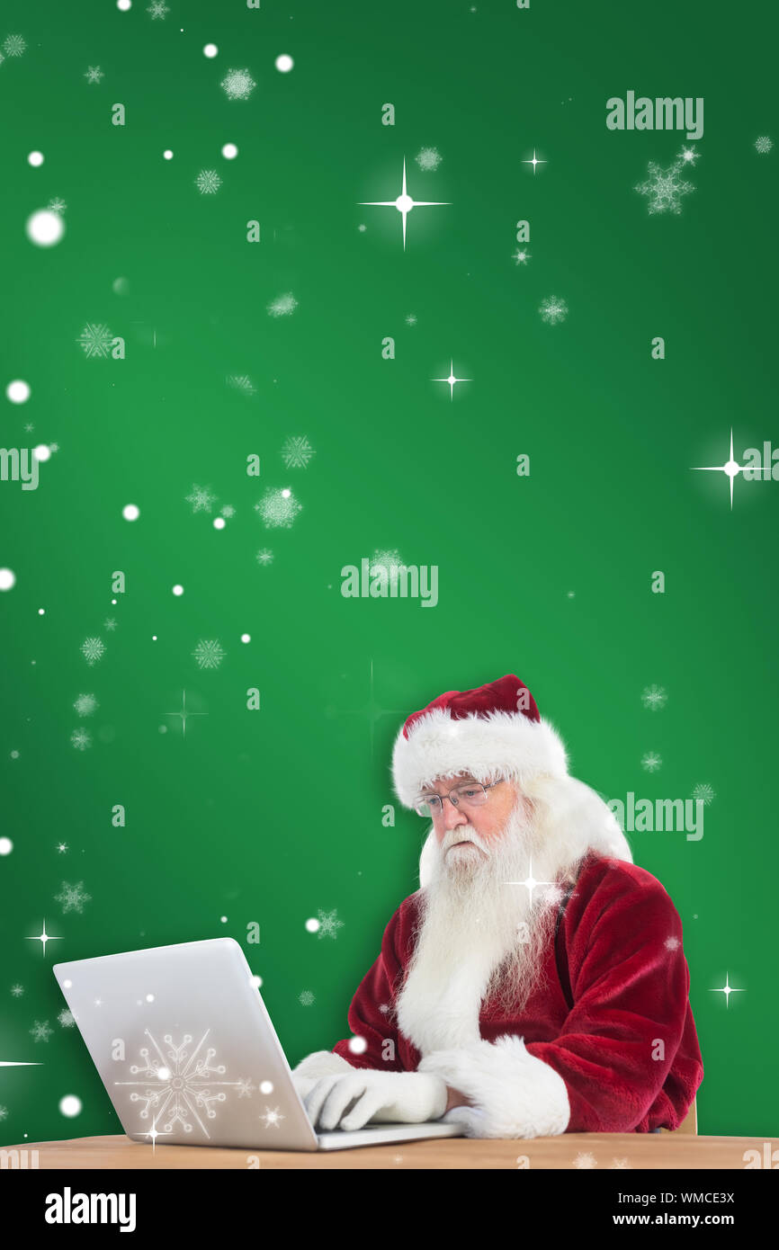 Santa surft im Internet gegen Grün Stockfoto