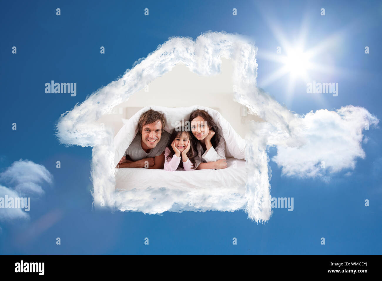 Lächelnd Eltern unter einer Bettdecke, und mit ihrer Tochter gegen strahlend blauen Himmel mit Wolken Stockfoto