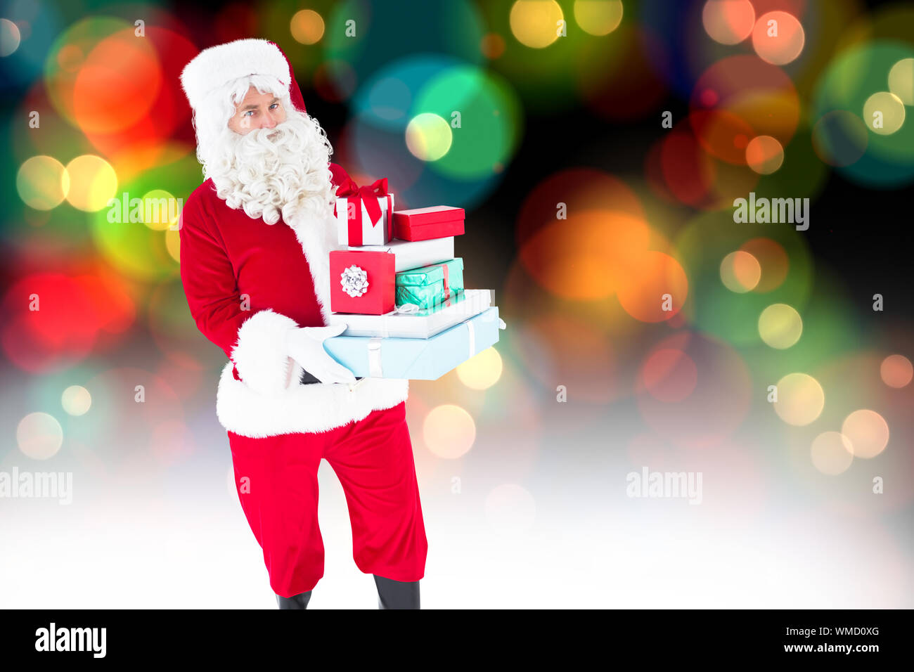 Der Weihnachtsmann viele Geschenke gegen bunt leuchtenden Punkte auf Schwarz Stockfoto