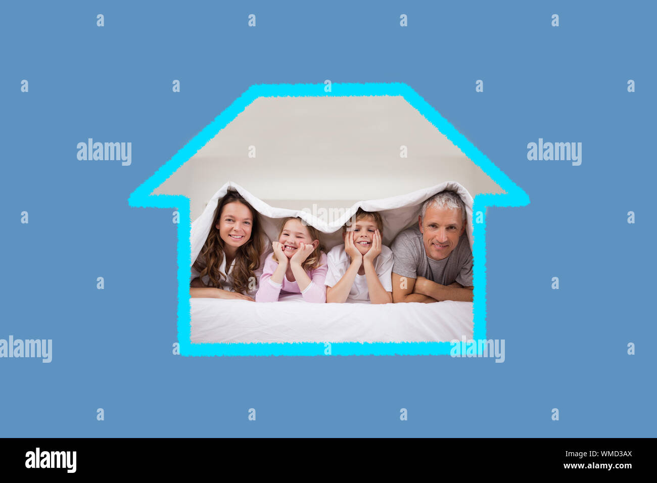 Verspielte Familie unter einer Bettdecke vor blauem Hintergrund liegend mit Vignette Stockfoto